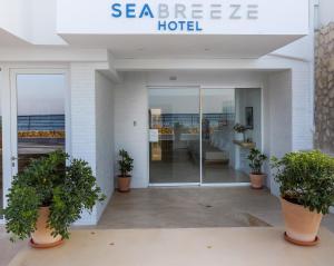 a hotel with potted plants in front of a building at Sea Breeze Hotel in Hersonissos