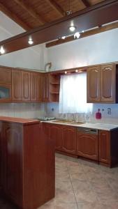 a large kitchen with wooden cabinets and a window at Melana Apartment in Tyros
