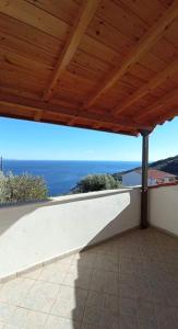 un porche con techo y vistas al océano en Melana Apartment en Tirós