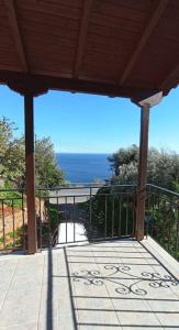 a balcony with a view of the ocean from a house at Melana Apartment in Tyros