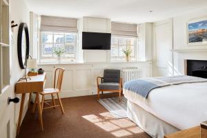 a bedroom with a bed and a desk and a chair at Admiral's House by Maison Pierre in Plymouth