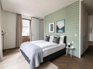 a bedroom with a large bed with a green wall at Limehome Linz Schillerstraße in Linz +38 photos