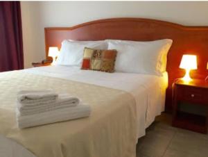 Un dormitorio con una cama blanca con toallas. en Buon Hotel Bologna Centro - Affittacamere - Self Check-In, en Bolonia