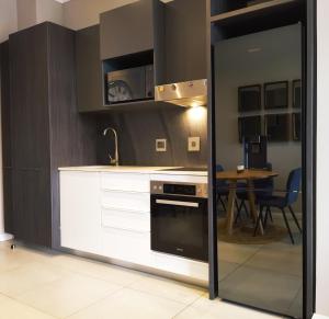 a kitchen with white cabinets and a stove and a table at Trilogy Apartment - Sapphire Gold in Pretoria