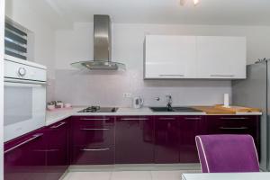 a kitchen with purple cabinets and a purple chair at Apartment Mario in Strožanac +12 photos
