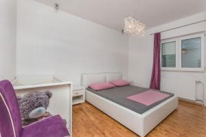 a small bedroom with a bed and a purple chair at Apartment Mario in Strožanac