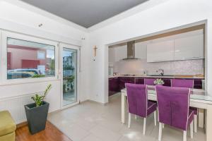 a kitchen with purple chairs and a table at Apartment Mario in Strožanac