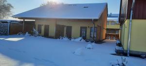 a house with snow on the ground in front of it at Ferienwohnung Schoch in Rust