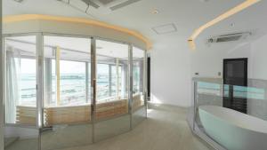 um quarto com janelas grandes e uma mesa de vidro em THIRD ishigakijima em Ishigaki
