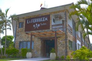 a building with a sign on the front of it at La Ferrugem Suites - 100 mts da Praia in Garopaba