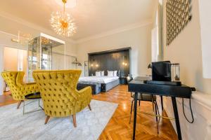 a living room with a bed and a desk and chairs at Mid City Apartments in Cluj-Napoca