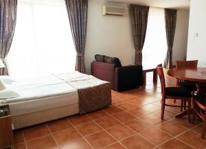 a bedroom with a bed and a table and a couch at Apart Hotel Efir in Sunny Beach +19 photos