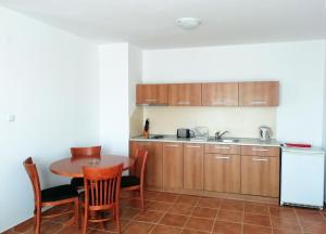a kitchen with a table and chairs and a refrigerator at Apart Hotel Efir in Sunny Beach