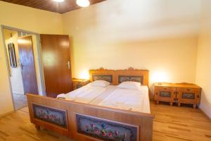 ein Schlafzimmer mit einem großen Bett und zwei Nachttischen in der Unterkunft Apartment Schmid - Steinbock Lodges in Maishofen