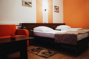 ein Schlafzimmer mit einem Bett, einem Stuhl und einem Tisch in der Unterkunft Kosmos Hotel in Jaroslawl