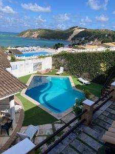 a swimming pool with a view of the ocean at Apartamentos Ponta do Sol in Natal