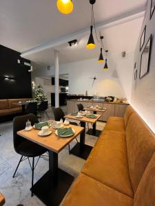 een woonkamer met tafels en een bank bij Hotel Montovani in Brugge