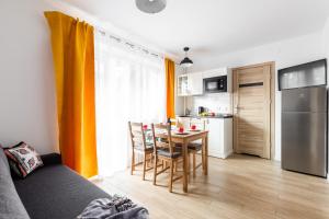 cocina con mesa y sillas en una habitación en Dom Pod Gubałówką - Zakopane Apartamenty, en Zakopane