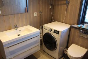a bathroom with a washing machine and a sink at Skarvhytta - moderne hytte med flott beliggenhet in Hol