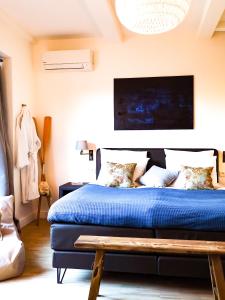 Schlafzimmer mit einem Bett mit blauer Decke in der Unterkunft B&B Tholen t’Uusje in Tholen