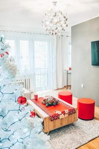 ein Wohnzimmer mit einem Weihnachtsbaum und roten Stühlen in der Unterkunft Apartament Piaseckiego in Zakopane