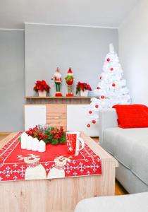ein Wohnzimmer mit einem Weihnachtsbaum und einem Couchtisch in der Unterkunft Apartament Piaseckiego in Zakopane