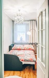 Schlafzimmer mit einem Bett, einem Fenster und einem Kronleuchter in der Unterkunft Apartament Piaseckiego in Zakopane