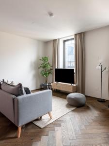 a living room with a couch and a flat screen tv at limehome Linz Schillerstraße in Linz