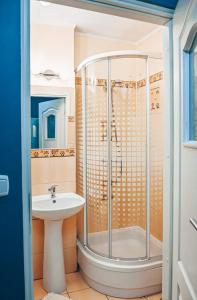 ein Bad mit einer Dusche und einem Waschbecken in der Unterkunft Apartament Piaseckiego in Zakopane