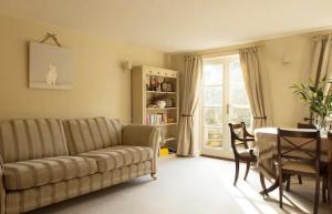 a living room with a couch and a table at Old Forge Close, Pretty 3 Bed Cottage in Bledington, The Cotswolds in Bledington