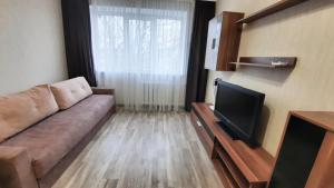 a living room with a couch and a flat screen tv at Двухкомнатная квартира 500м от моря ул Парковая отчетные док in Chornomorsk