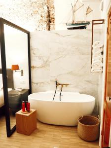 uma banheira na casa de banho com um espelho em B&B Tholen em Tholen
