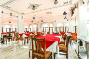 a dining room with red tables and chairs at Hotel Pichola Haveli in Udaipur