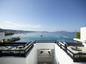 een glazen huis met uitzicht op het water bij Nimbus Mykonos in Agios Stefanos