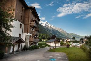 a building with a snow covered mountain in the background at Apartment Blaitiere - luxurious 2 bed apartment in Chamonix