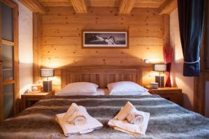a bedroom with a bed with two towels on it at Apartment Blaitiere - luxurious 2 bed apartment in Chamonix-Mont-Blanc +7 photos