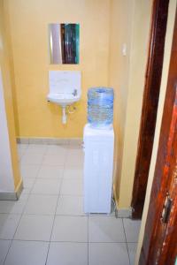 a bathroom with a toilet and a sink with a trash can at Fika Casa in Nakuru