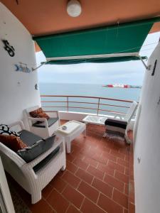 a balcony with chairs and tables on a boat at Cristianmar, Los Cristianos in Los Cristianos