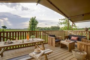 eine Terrasse mit einem Tisch und Stühlen auf einer Holzterrasse in der Unterkunft Village Flottant de Pressac in Pressac