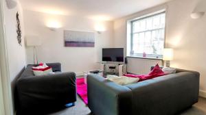 a living room with two couches and a tv at Self contained, Garden Flat, Montpellier Villas in Cheltenham