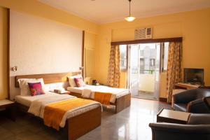una camera d'albergo con due letti e una televisione di Sea Green South Hotel a Mumbai