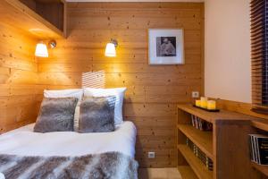 ヴァル・トランスにあるVal Thorens-Cosy Lauzières 315の木製の壁のベッドルーム1室、ベッド1台(枕2つ付)