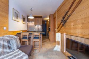 a living room with a couch and a kitchen with a fireplace at Val Thorens-Cosy Lauzières 315 in Val Thorens +10 photos