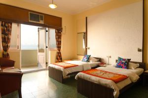 a hotel room with two beds and a balcony at Sea Green South Hotel in Mumbai