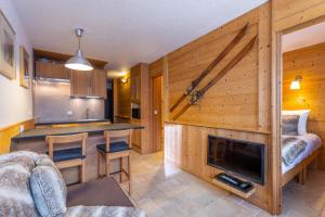 a kitchen and a living room with a fireplace at Val Thorens-Cosy Lauzières 315 in Val Thorens