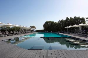 een groot zwembad met stoelen en parasols bij NEMA Design Hotel & Spa - Adults Only in Chersonissos