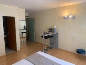 a bedroom with a bed and a table and a bar at Appart'Hôtel Residence Dizerens in Geneva