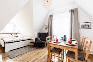 1 dormitorio con 1 cama, mesa y sillas en Dom Pod Gubałówką - Zakopane Apartamenty, en Zakopane