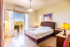 a bedroom with a bed and a balcony at PLEIADES lUXURY APARTMENTS in Porto Heli