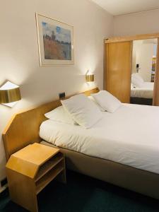 ein Hotelzimmer mit 2 Betten und einem Spiegel in der Unterkunft Hotel Prado in Ostende